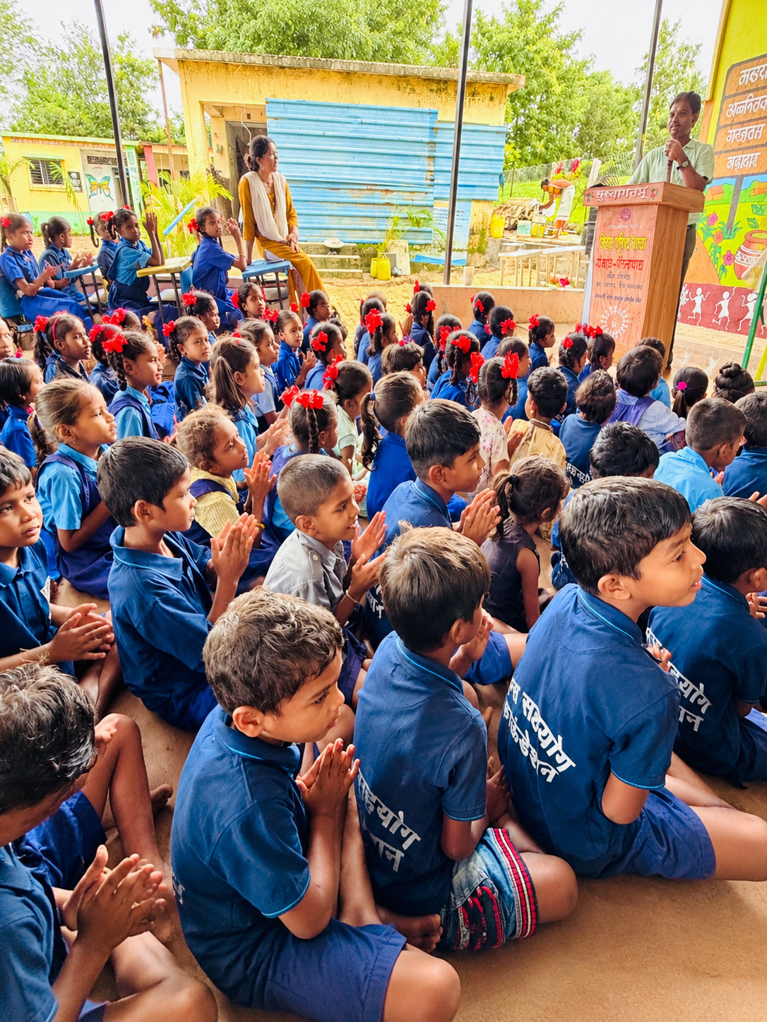Schoolchildren listening to a speaker at a school gathering